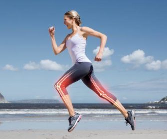 A fit, young woman running on the beach.